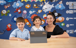 A photo of a teacher with two students happily learning and on the journey to 2025 NAPLAN success